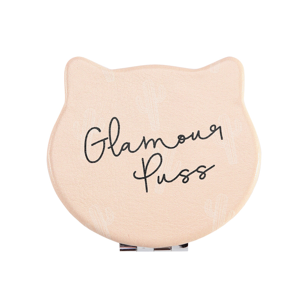 Front view of the Compact Kitty Mirror shaped as a cat head. Outside of mirror is light orange and has black writing saying: Glamour Puss
