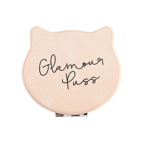 Front view of the Compact Kitty Mirror shaped as a cat head. Outside of mirror is light orange and has black writing saying: Glamour Puss