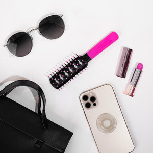 Front of the Static Free Mini Fast Flo Colors in Hot Pink, next to sunglasses, lipstick, iphone & handbag