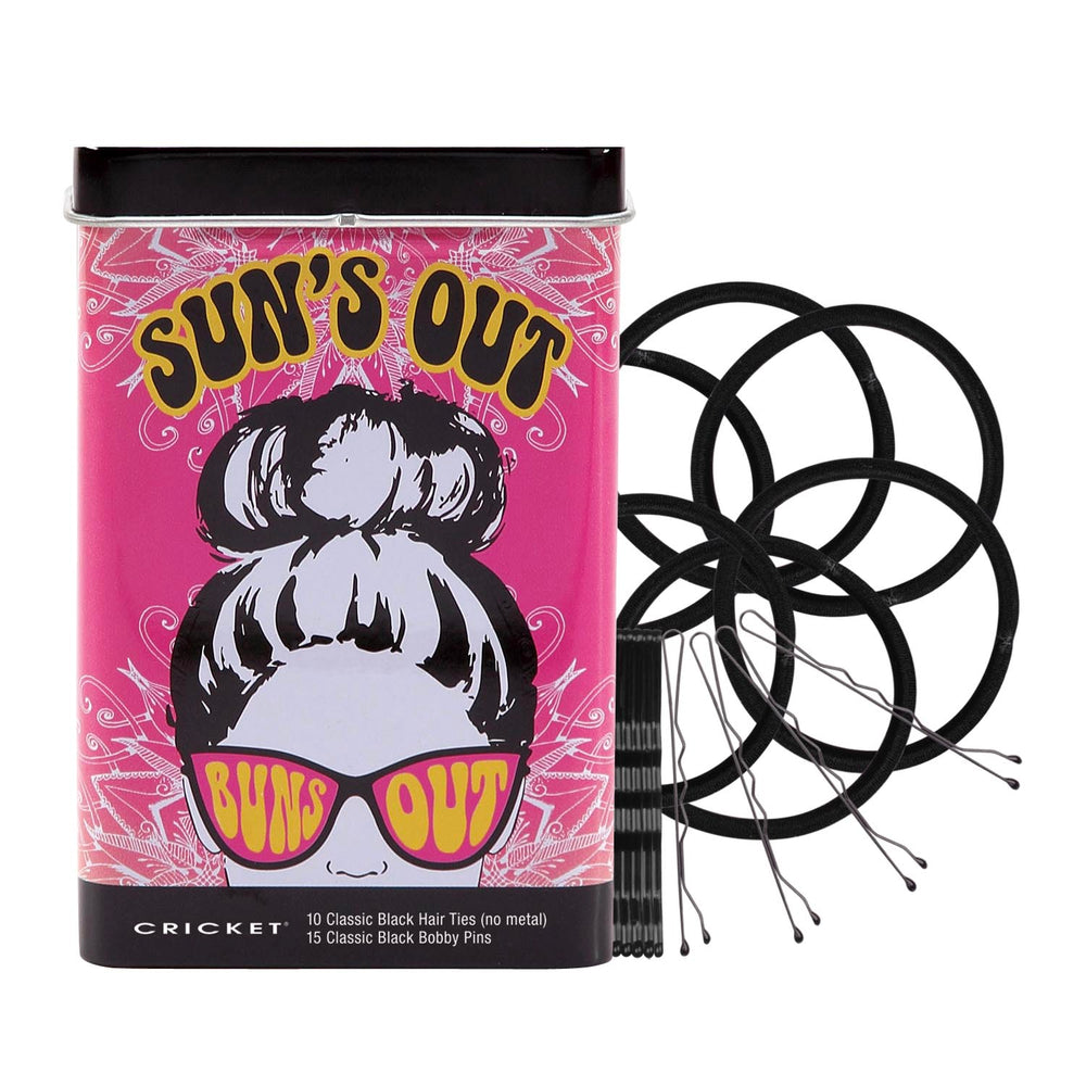 A cylindrical tin of Cricket 'Sun's Out' classic black hair ties and bobby pins on a plain white background. The packaging features a vibrant pink background with a retro illustration of a woman with a high bun wearing pink 'Sun's Out' sunglasses. Cricket logo at the bottom, with the contents of the tin: 10 Classic Black Hair Ties (no metal) and 15 Classic Black bobby pins.