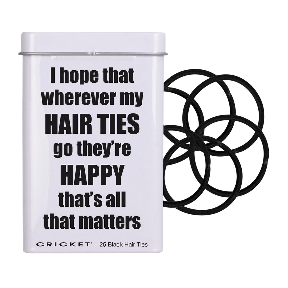 A white rectangular tin with a lid  featuring the humorous text 'I hope that wherever my HAIR TIES go they're HAPPY that's all that matters' in bold black lettering. The brand 'CRICKET' is printed at the bottom along with '25 Black Hair Ties'.
