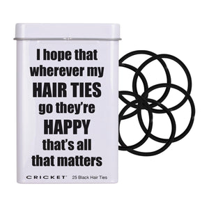 A white metal tin with a humorous quote about hair ties, shown next to several black elastic hair ties on a plain white background.