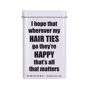 A white rectangular tin with a lid  featuring the humorous text 'I hope that wherever my HAIR TIES go they're HAPPY that's all that matters' in bold black lettering. The brand 'CRICKET' is printed at the bottom along with '25 Black Hair Ties'.