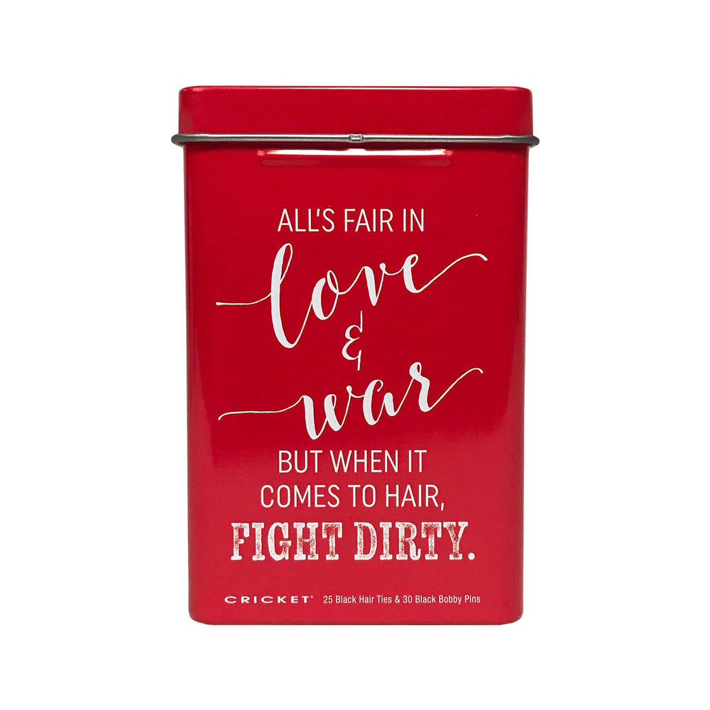 A red rectangular metal tin with a lid, featuring white printed text that reads, 'ALL'S FAIR IN love & war BUT WHEN IT COMES TO HAIR, FIGHT DIRTY.' Small text at the bottom reads 'CRICKET' and '25 Black Hair Ties & 30 Black Bobby Pins.