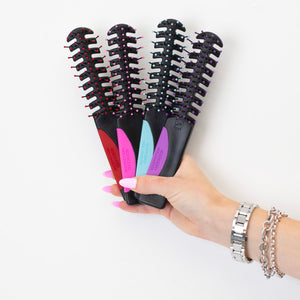 A hand holding the 4 Static Free Volumizer Vent Hair Brushes in new colors, Red, Hot Pink, Blue & Purple