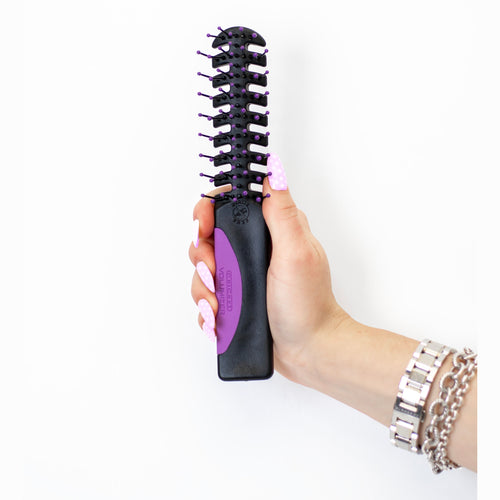 A hand holding Static Free Volumizer Vent Hair Brush in Purple