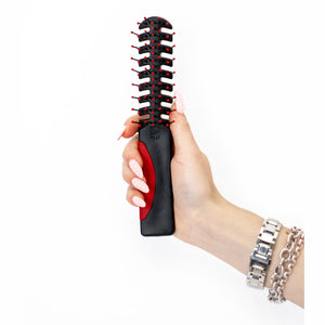 A hand holding Static Free Volumizer Vent Hair Brush in Red 