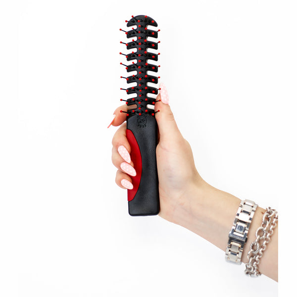 A hand holding Static Free Volumizer Vent Hair Brush in Red 