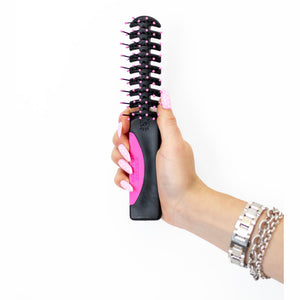 A hand holding Static Free Volumizer Vent Hair Brush in Hot Pink